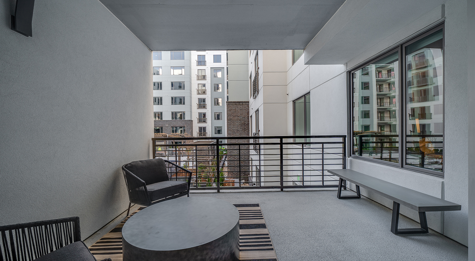 Peace Raleigh Apartments - Private Terrace with bench and view of surrounding apartments beyond the courtyard